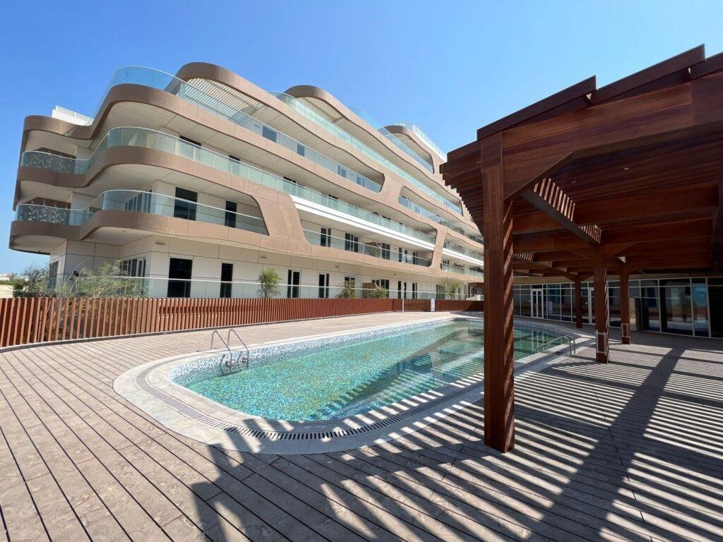 Aerial view of Qaryat Al Hidd by SDIC on Saadiyat Island showcasing luxury low-rise apartments and landscaped gardens.